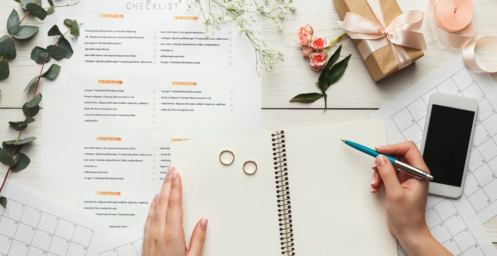 Mains feuilletant des plans techniques sur une table de travail, échantillons de matériaux colorés disposés à côté